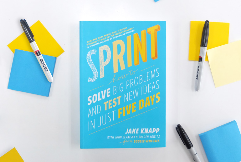 Click the photo of the Sprint book on a desk with sharpies and post-its to view of Google Design Sprint guide.