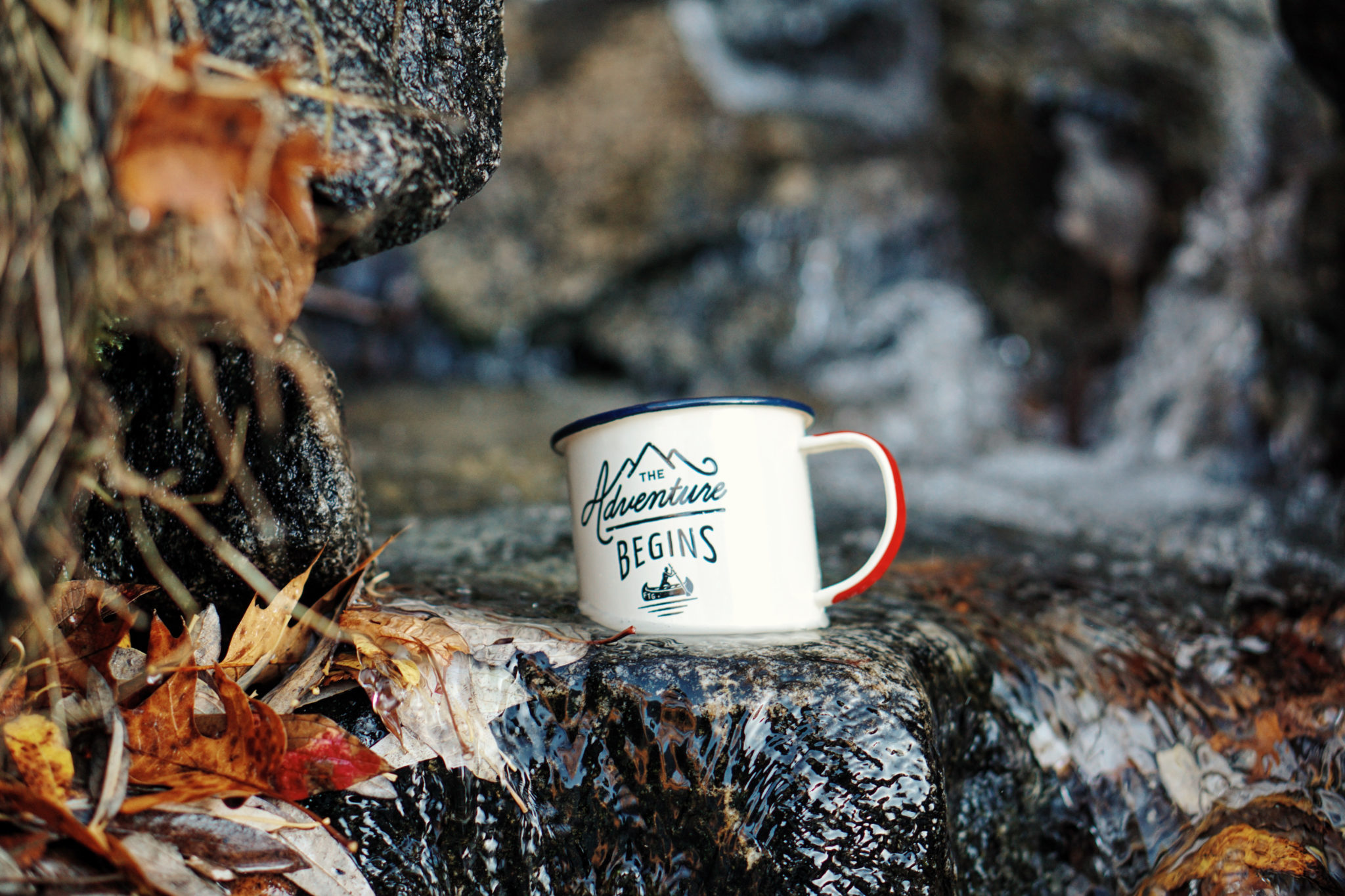 An enamel mug reading 'The adventure begins' sits in a stream. The Team Charter sets ground rules for the upcoming project.