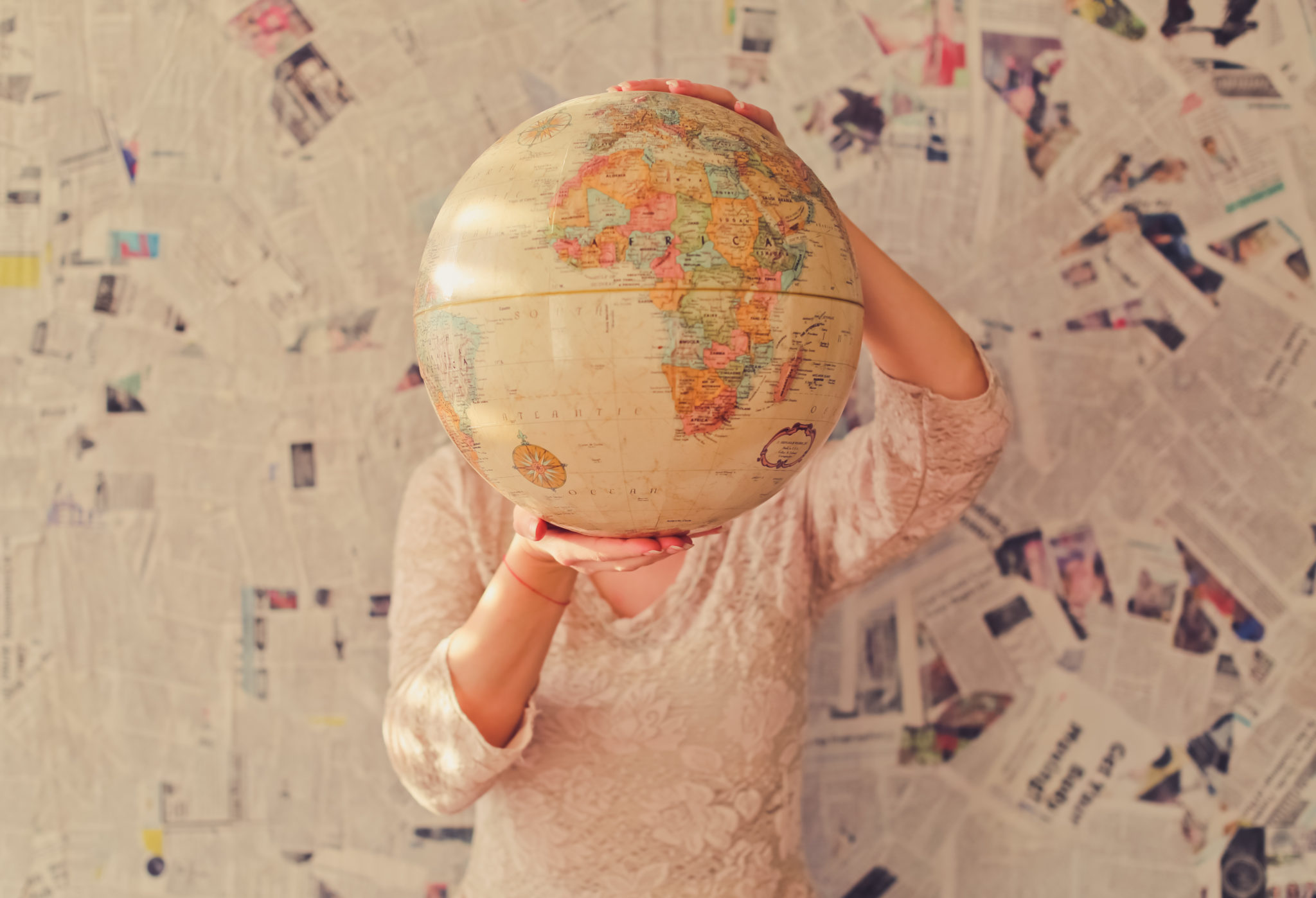 A woman holds up a globe. User story mapping guides you to your destination - building your product.